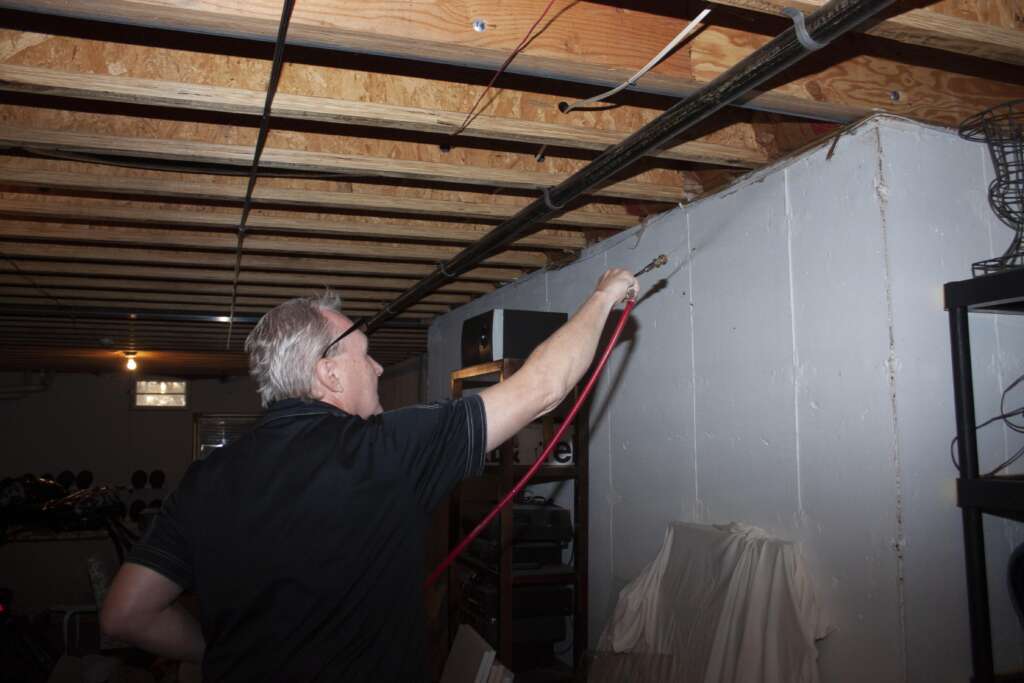 technician spraying basement